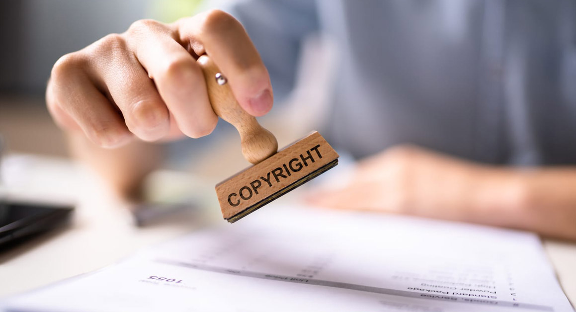 Une personne appose un tampon "COPYRIGHT" sur un document